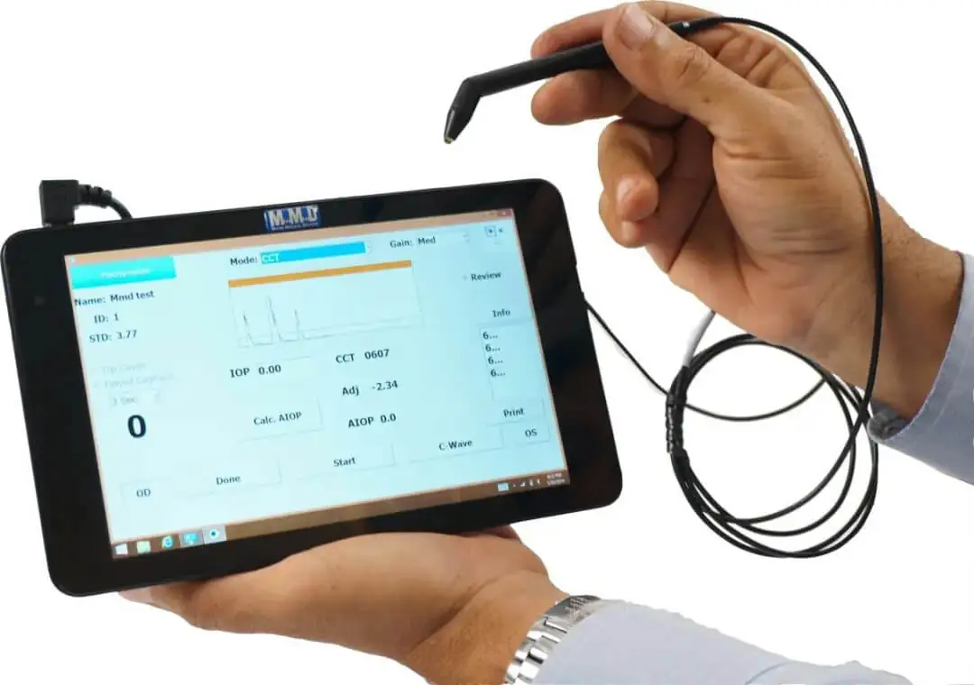 A person holds a digital tablet displaying technical data, using a connected stylus or probe device, suggesting usage for measurements or diagnostics.